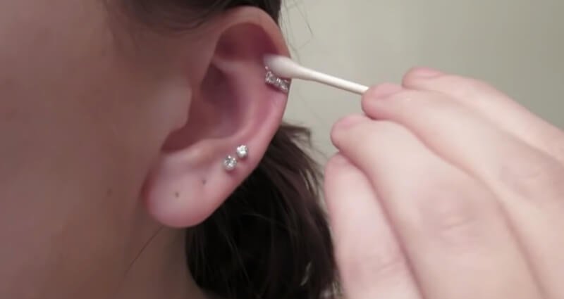 Carefully cleaning piercing